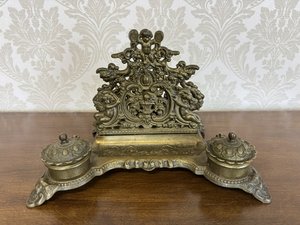 Zdobený mosazný kalamář s figurálními motivy a barokními ornamenty