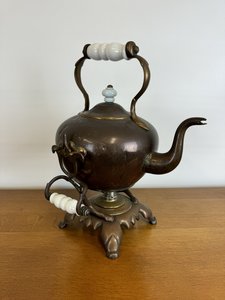 Mosazná čajová konvice s ohřívacím stojanem a keramickými držadly, r. 1910