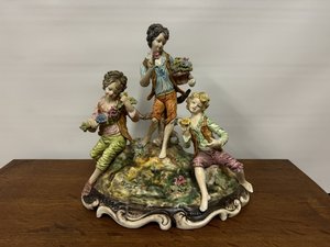 Porcelánová soška dětí na louce s květinami