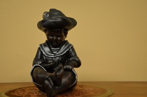 Soška dítěte s kloboukem a námořnickým límcem