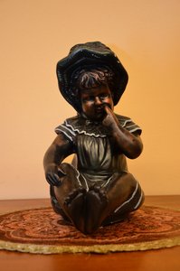 Soška sedícího dítěte s kloboučkem