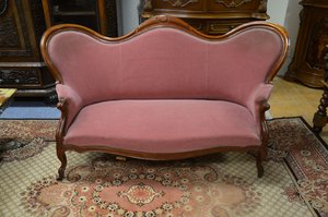 Pohovka s dřevěným rámem a růžovým čalouněním