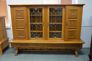 Prostorná vitrína s vyřezávanými dvířky a skleněnými vitrážemi