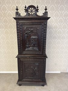 Příborníková skříň s figurálním reliéfem a ozdobnou korunkou