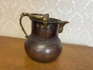 Nádoba s mosazným uchem a reliéfními hlavami 