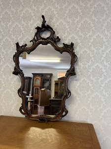 Zrcadlo s bohatě řezbovaným rámem