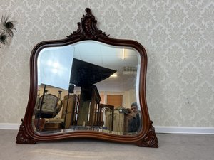 Zrcadlo s vyřezávaným rámem a bohatou dekorací