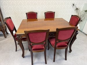 Jídelní stůl se šesti čalouněnými židlemi, vyřezávanými detaily