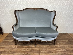 Elegantní sofa s křivkami a bohatě zdobeným rámem