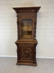 Vitrína s lví maskou a figurální řezbou v bohatě dekorovaném korpusu