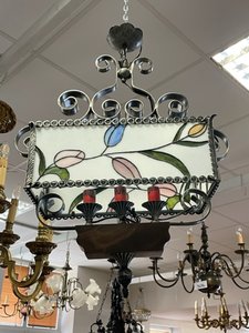 Kovový lustr s vitrážovým stínidlem a květinovými motivy, pochází ze stylu secese