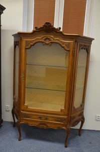 Elegantní vitrína s jemnými řezbami a prosklenými dvířky